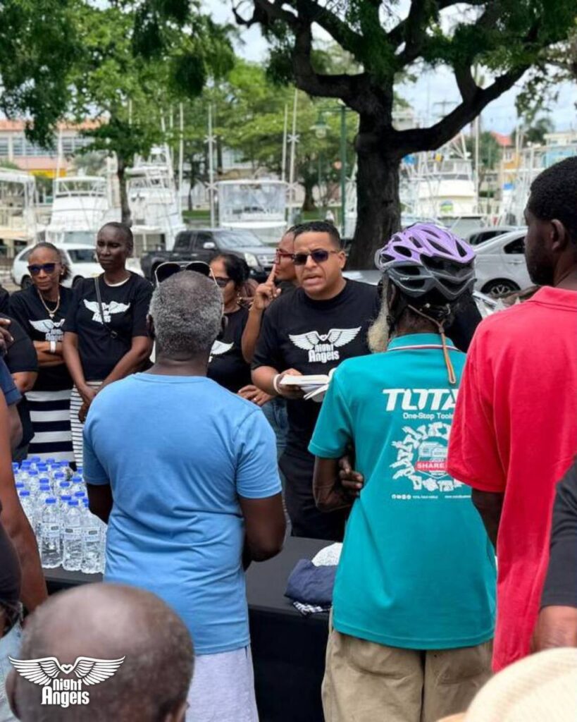 Night Angels volunteer speaking with people at National Heroes Square, Bridgetown